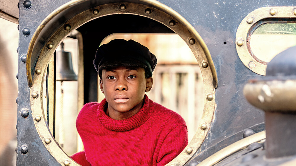 Szenenbild: Jim Knopf blickt hoffnungsvoll durch eine Luke von seiner kleinen Lokomotive, die Emma heißt.