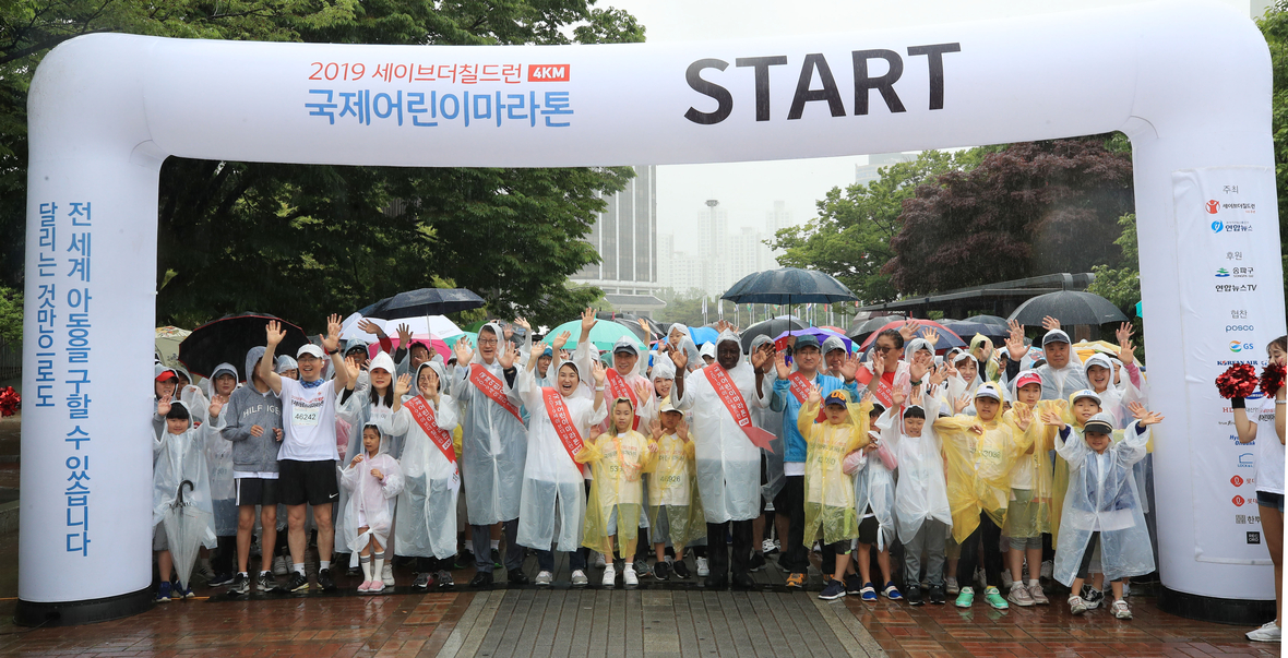 Spendenlauf in Seoul (Südkorea) organisiert von der Kinderhilfsorganisation Save the Children und einem Nachrichtendienst. Die jungen und alten Teilnehmende posieren in einem Park für ein Foto.