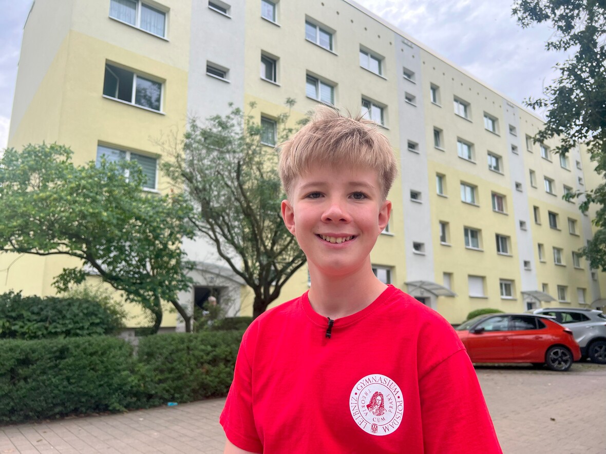 Jonas im roten T-Shirt vor einem Gebäude 