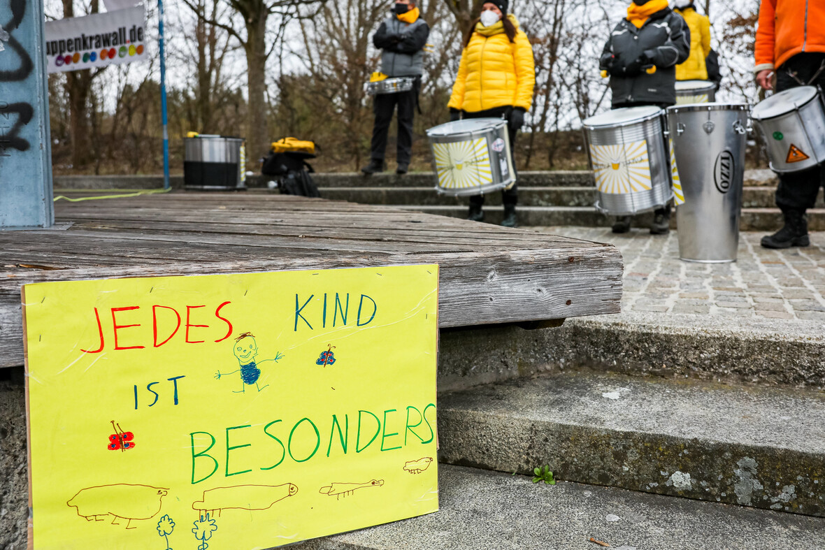 Gelbes Plakat mit der Aufschrift ‚Jedes Kind ist besonders‘ auf einer Demo 