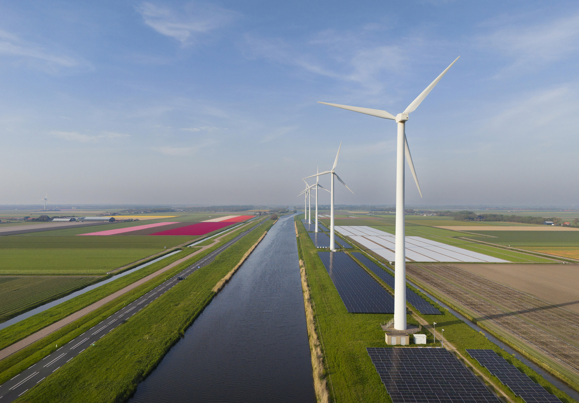 Die Wasserlinien sind typisch für das Landschaftsbild der Niederlande. Hier stehen Solaranlagen und Windräder neben Tulpenfeldern.