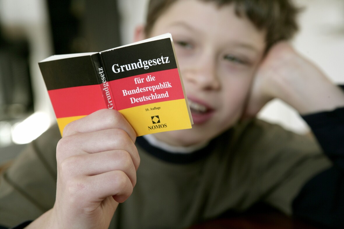 Ein Kind liest im Grundgesetz.