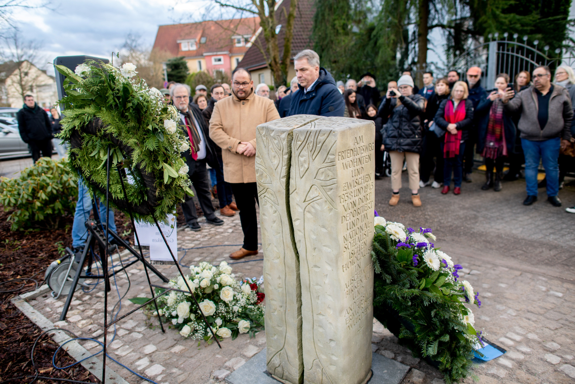 Menschen denken an Sinti und Roma, die in der Zeit des Nationalsozialismus verfolgt und getötet wurden. Es haben sich Menschen in Oldenburg, Niedersachsen, um einen Gedenkstein zusammengefunden. 