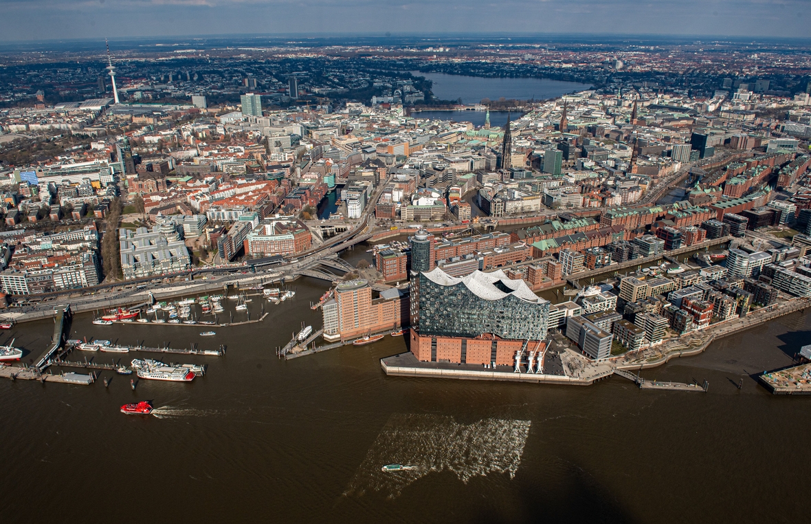 Das Luftbild zeigt die Elbphilharmonie im Hamburger Hafen, die Speicherstadt, das moderne Wohnviertel Hafencity, das Rathaus und im Hintergrund die Alster.