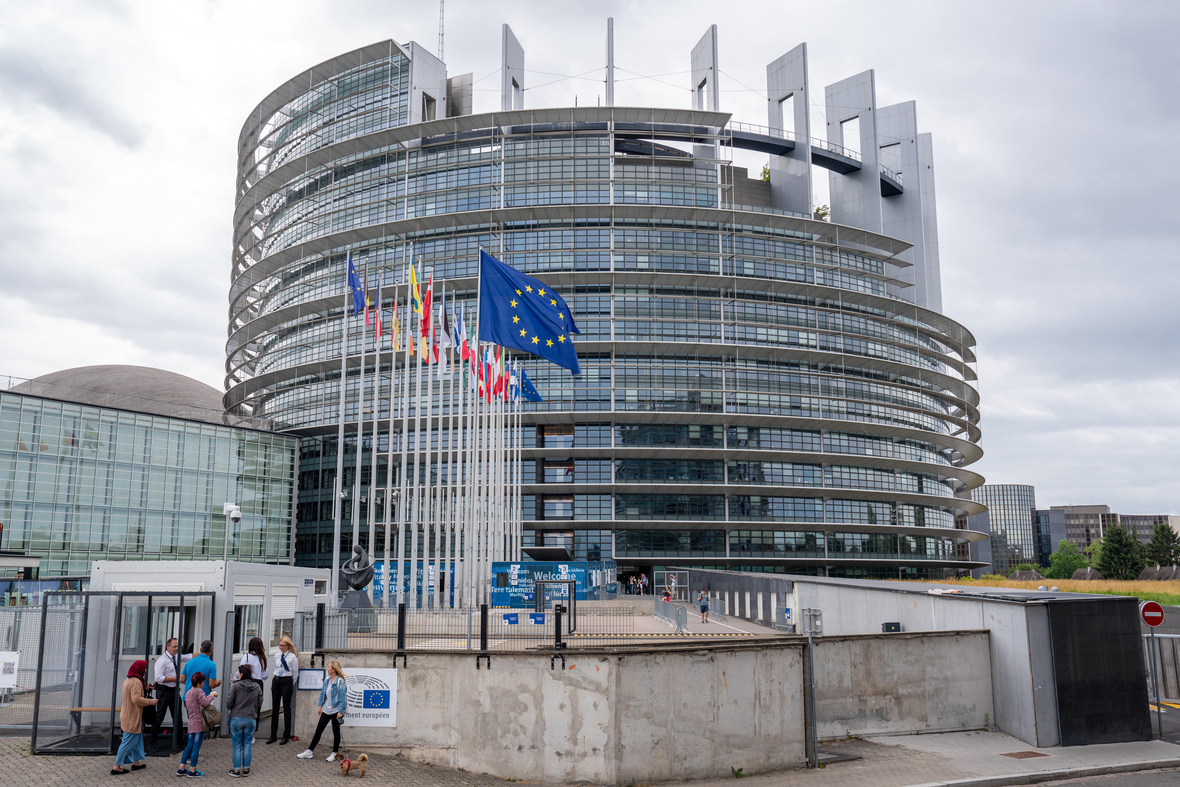 Das EU-Parlament in Straßburg - Blick auf das große runde Gebäude mit Fahnen davor.